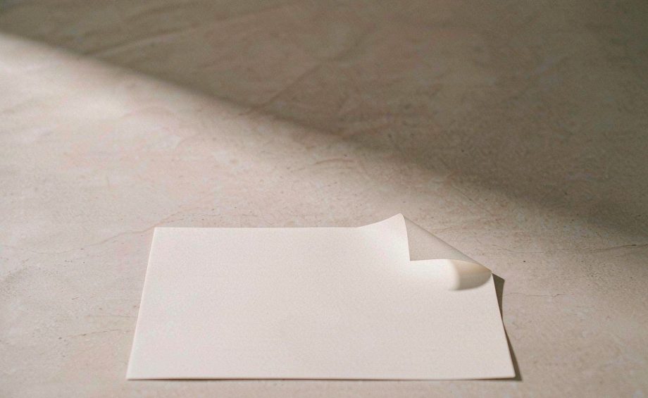 A blank sheet of paper resting on a pale stone surface